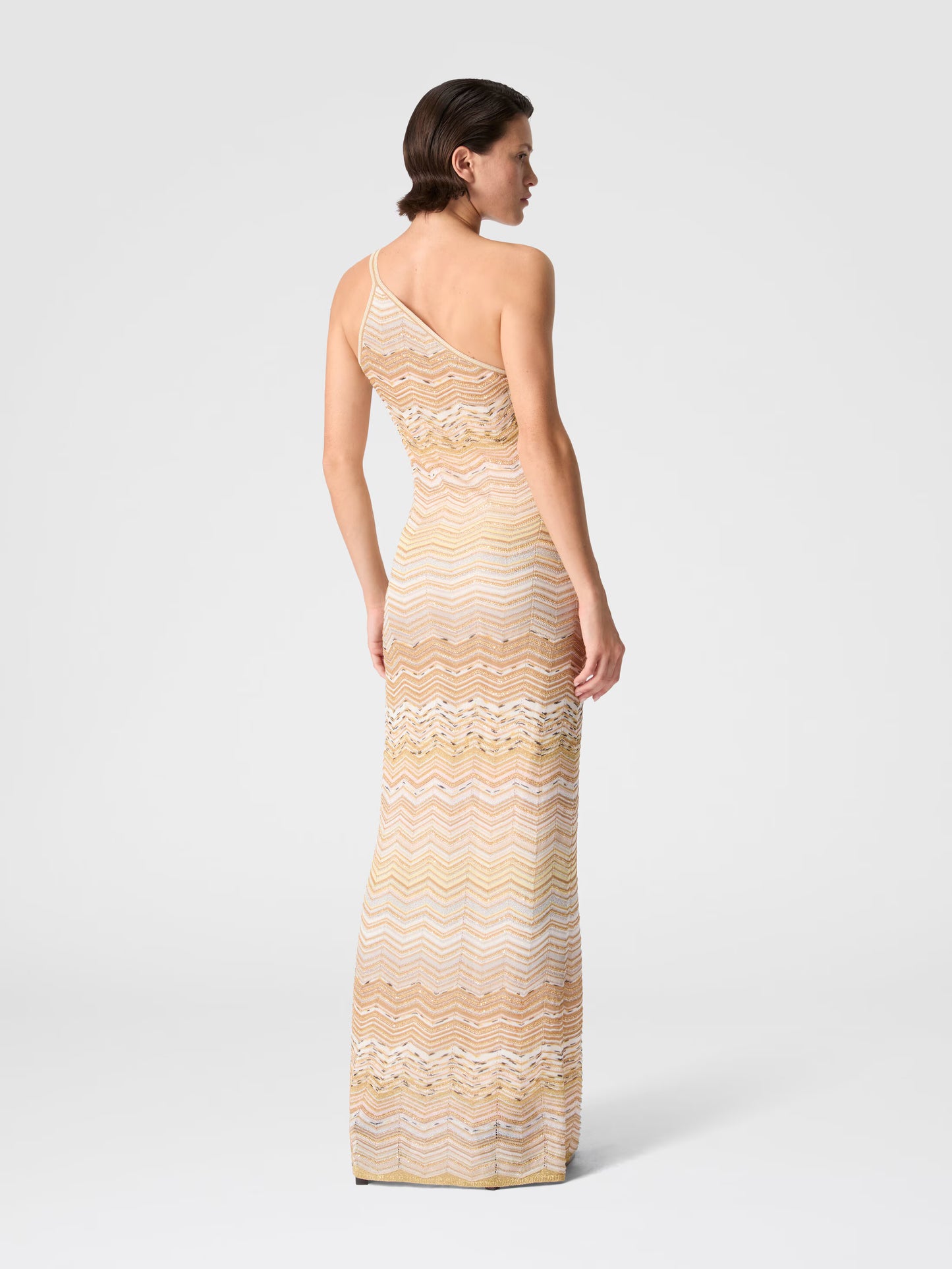 Woman wearing One shoulder Missoni zigzag patterned dress in Gold back view