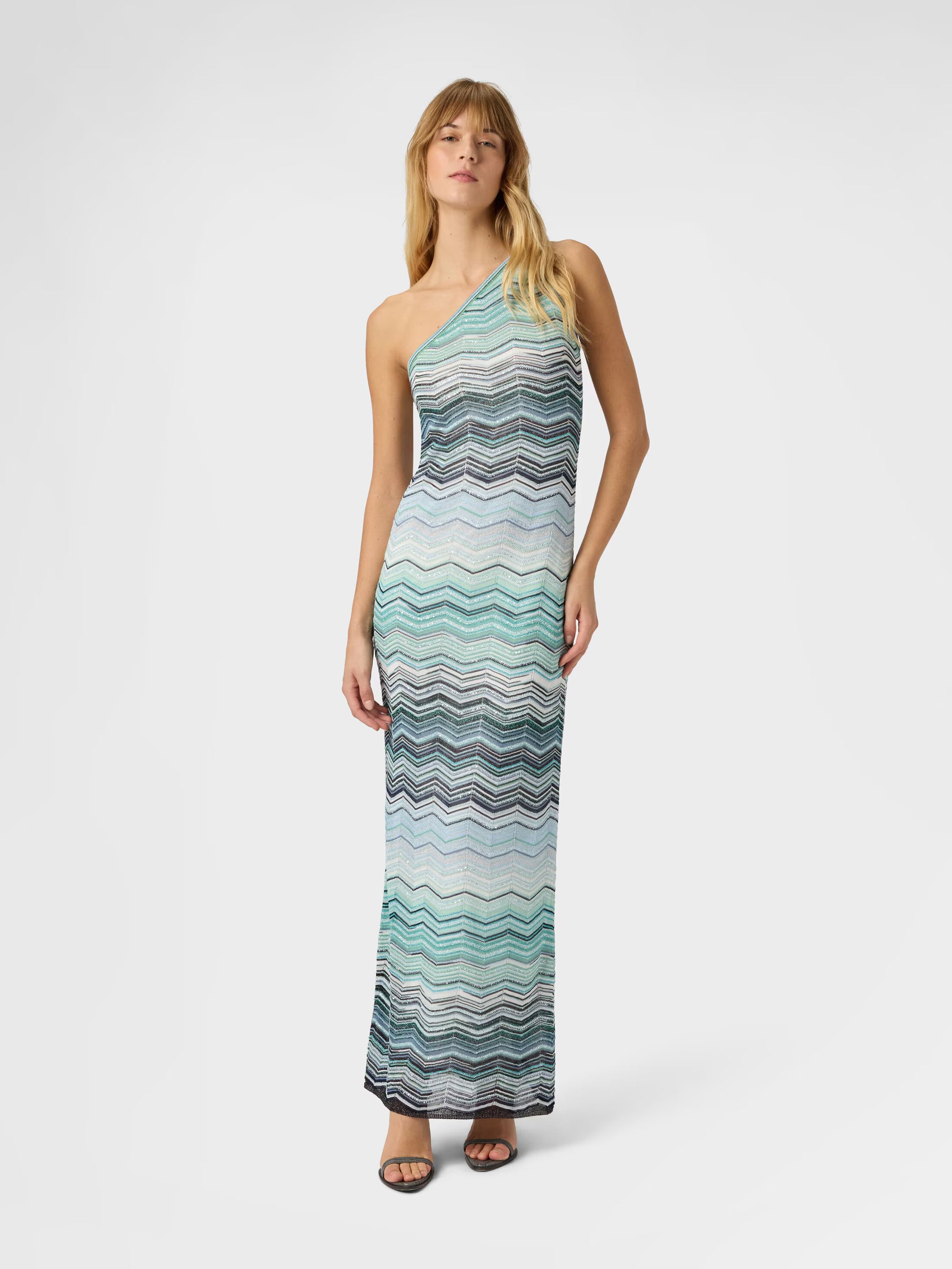 Woman wearing a Missoni one shoulder turquoise Missoni zigzag patterned dress 